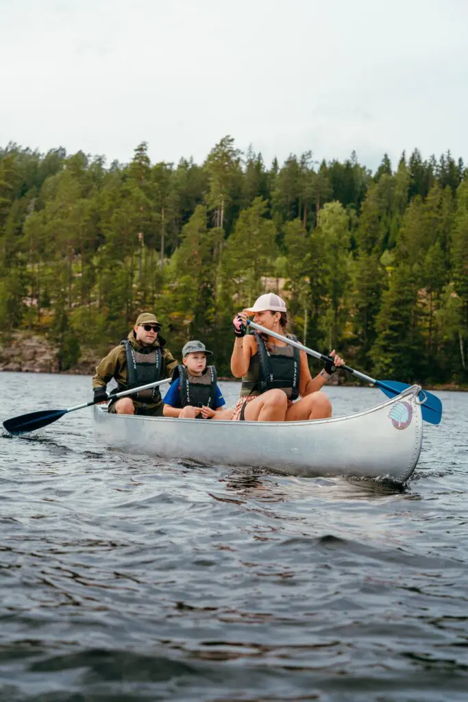 family canoeing on a lake with a forest in the background