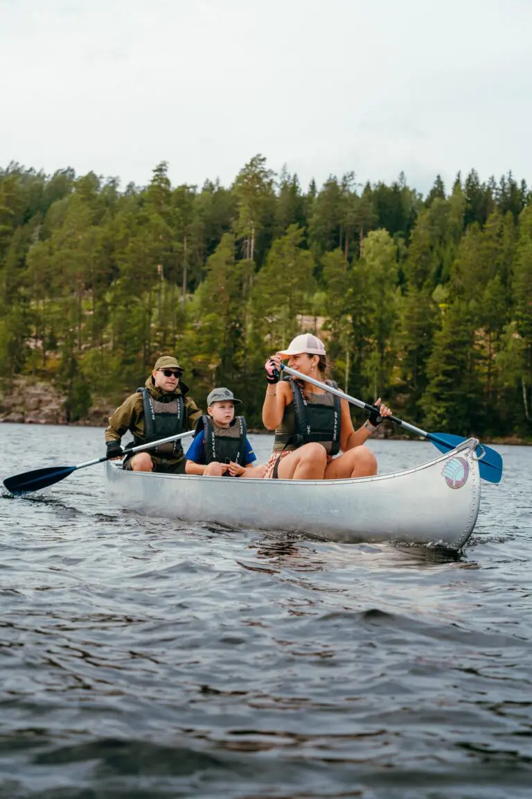 family canoeing on a lake with a forest in the background