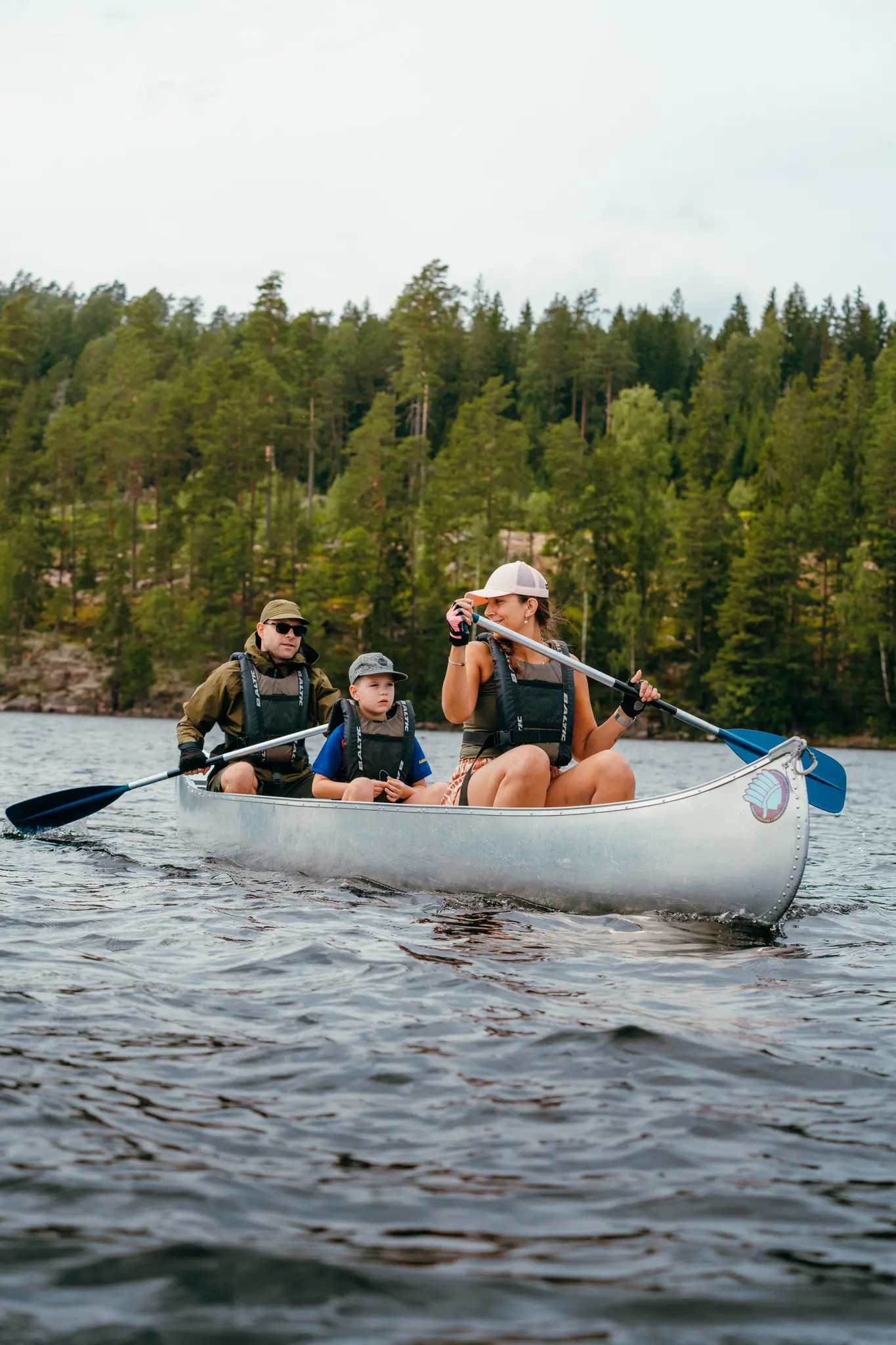 family canoeing on a lake with a forest in the background