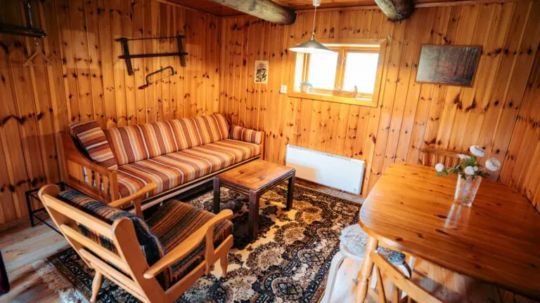 cozy wooden cabin interior with striped sofa and dining table