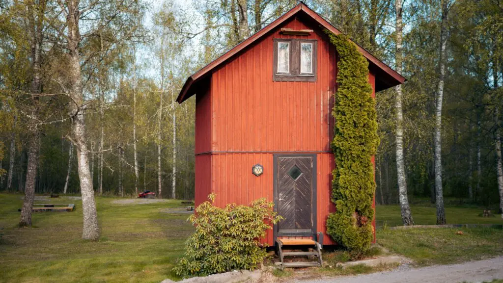 red lumberjack hut in a forest clearing