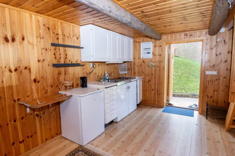 cozy lumberjack hut interior with small kitchen and wooden walls
