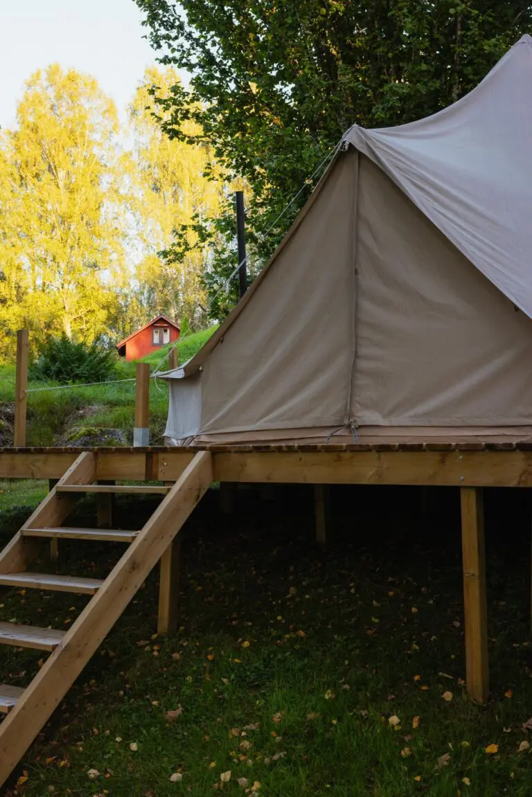 glamping tent on wooden deck with autumn trees in Sweden