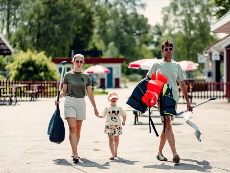 Family carrying paddles to go canoeing