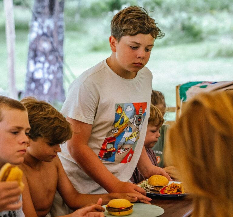 kids serving themselves burgers and fries at an outdoor meal
